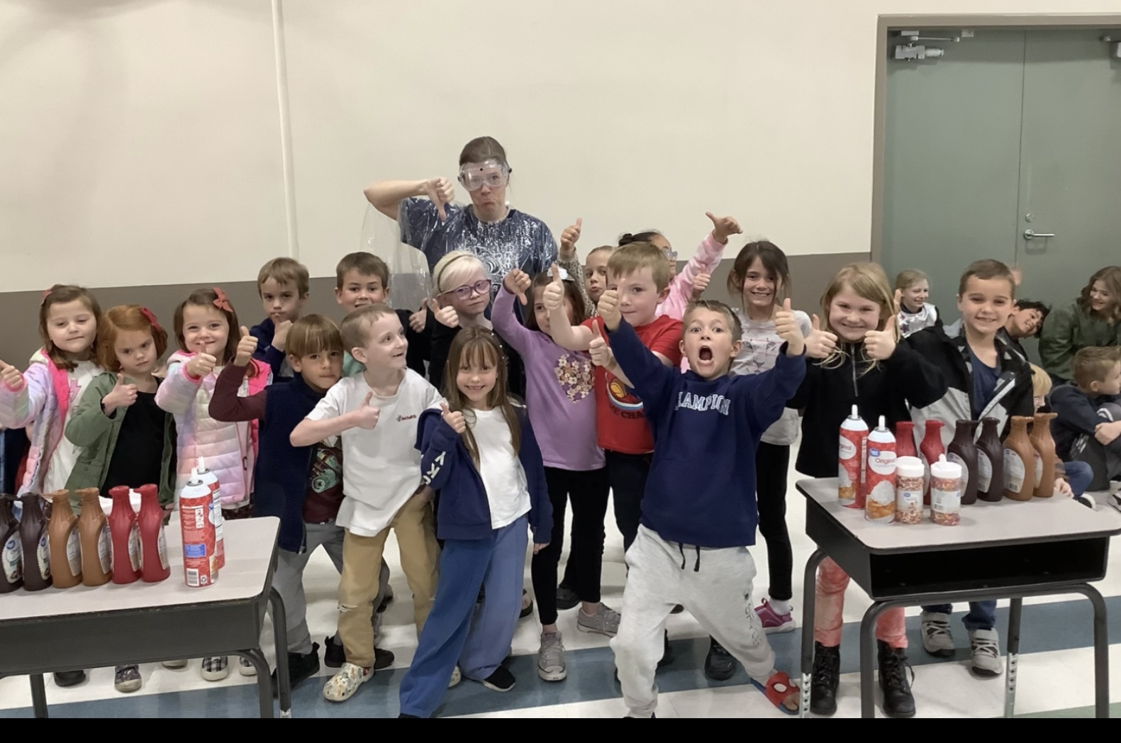 Children in cafeteria excited to make ice cream sundaes. 